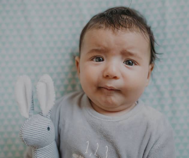 Newborn baby looking uncomfortable and fussy