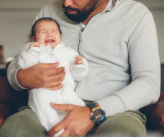 Man holding crying baby