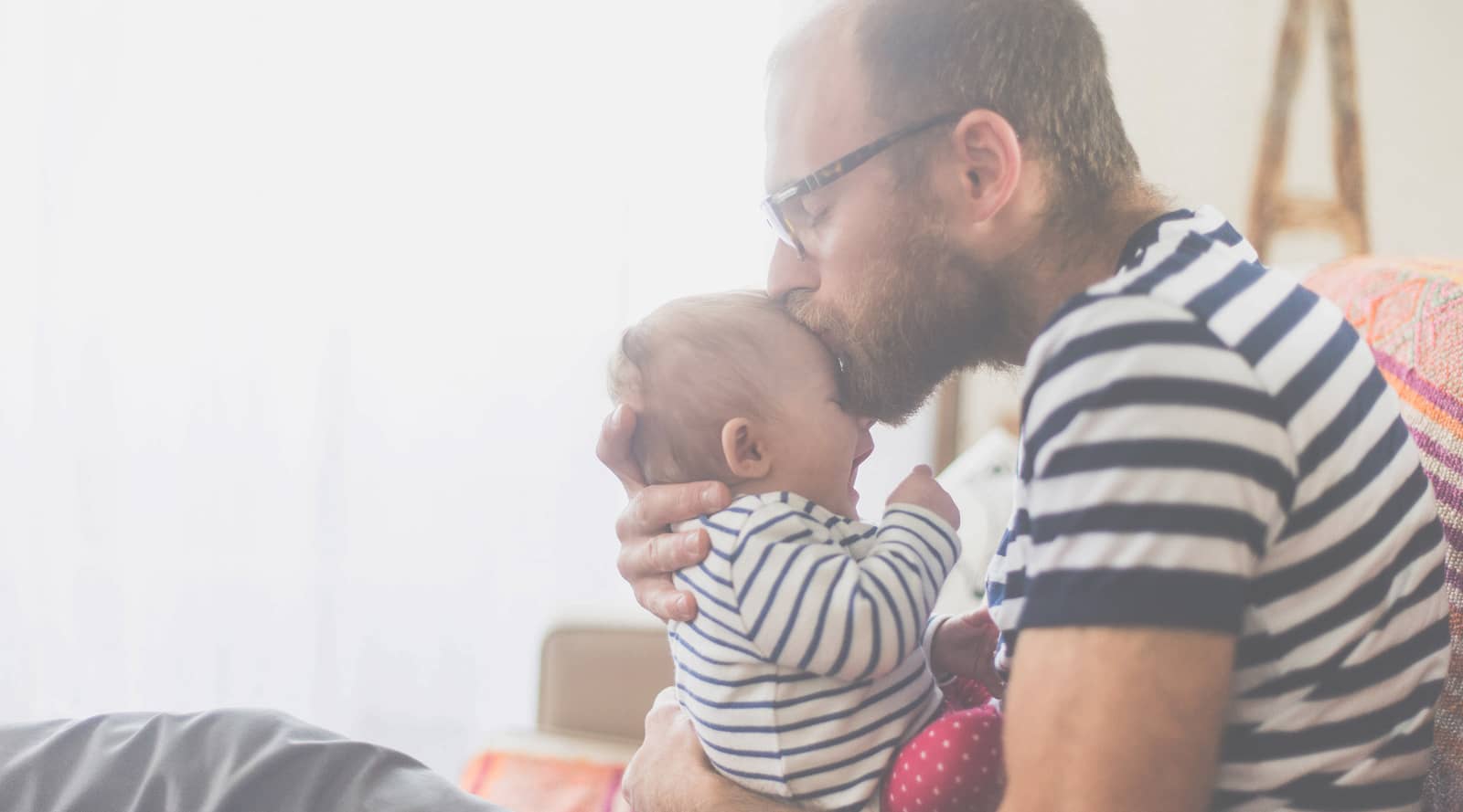 Man kissing baby on the forehead