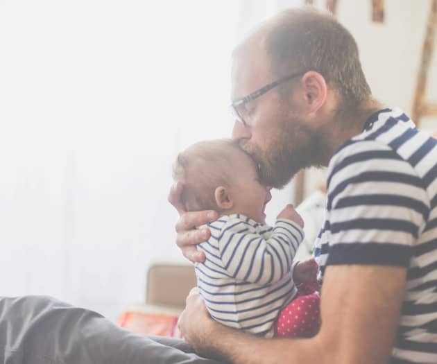 Man kissing baby on the forehead