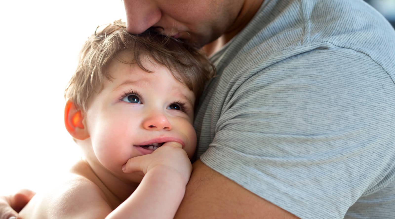 young boy cuddled up to his father