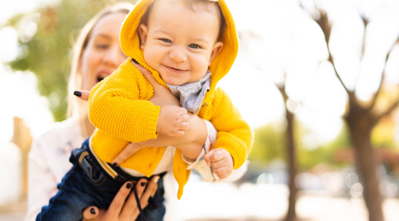 Mother holding a baby in a park