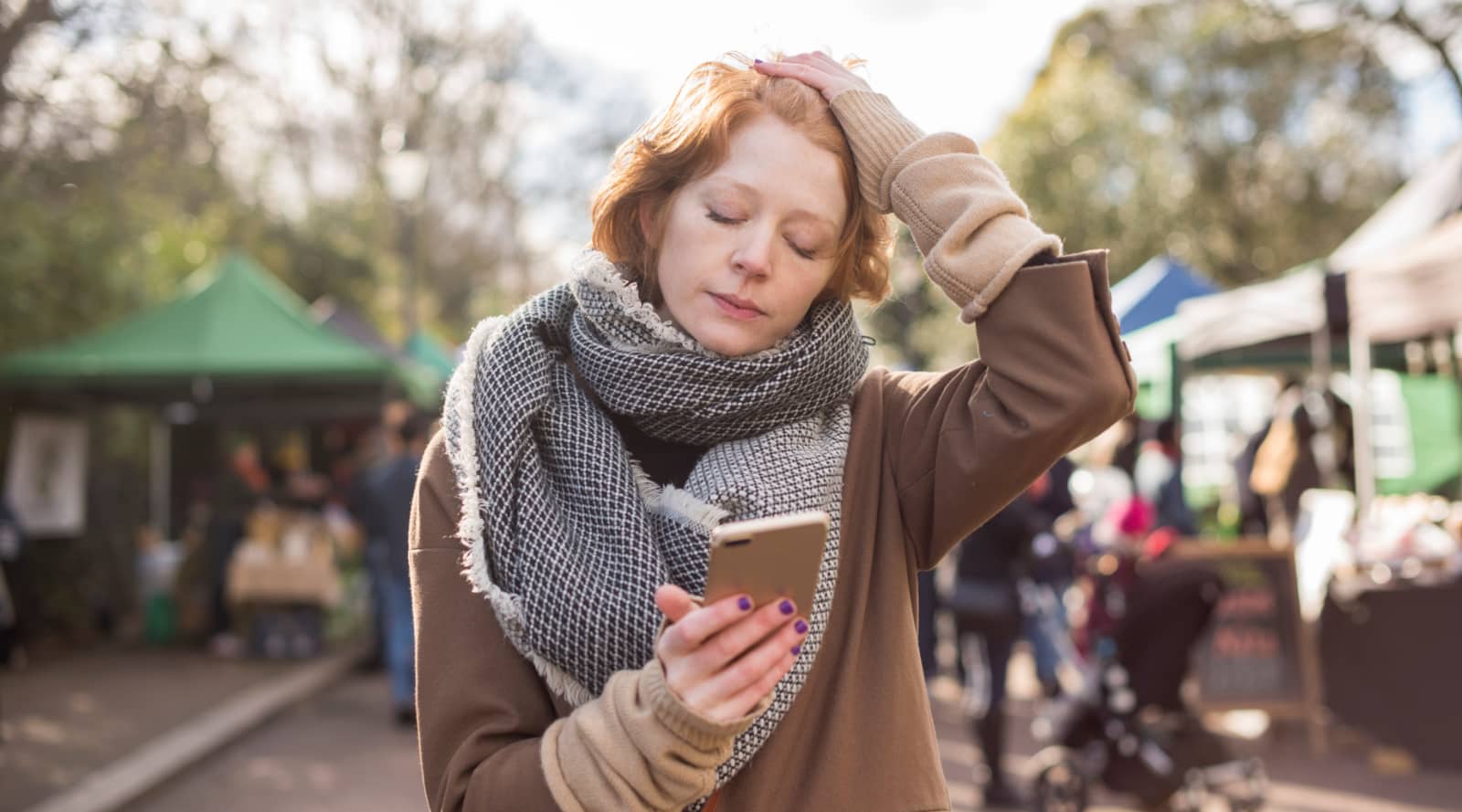 Stressed woman holding a phone with her eyes closed