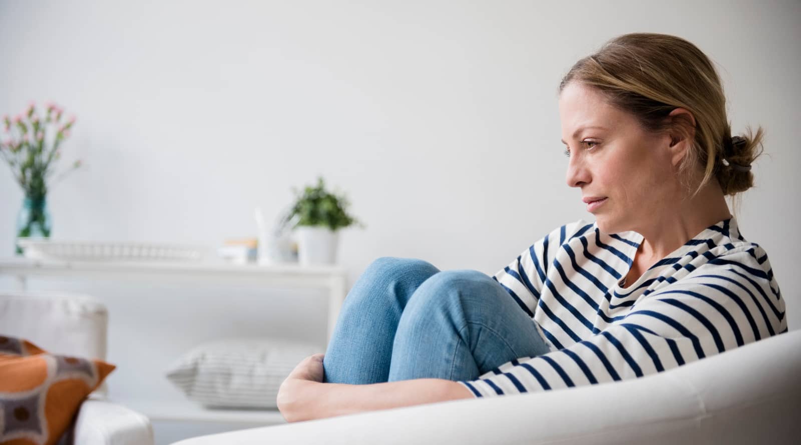 Woman sat on the sofa looking depressed