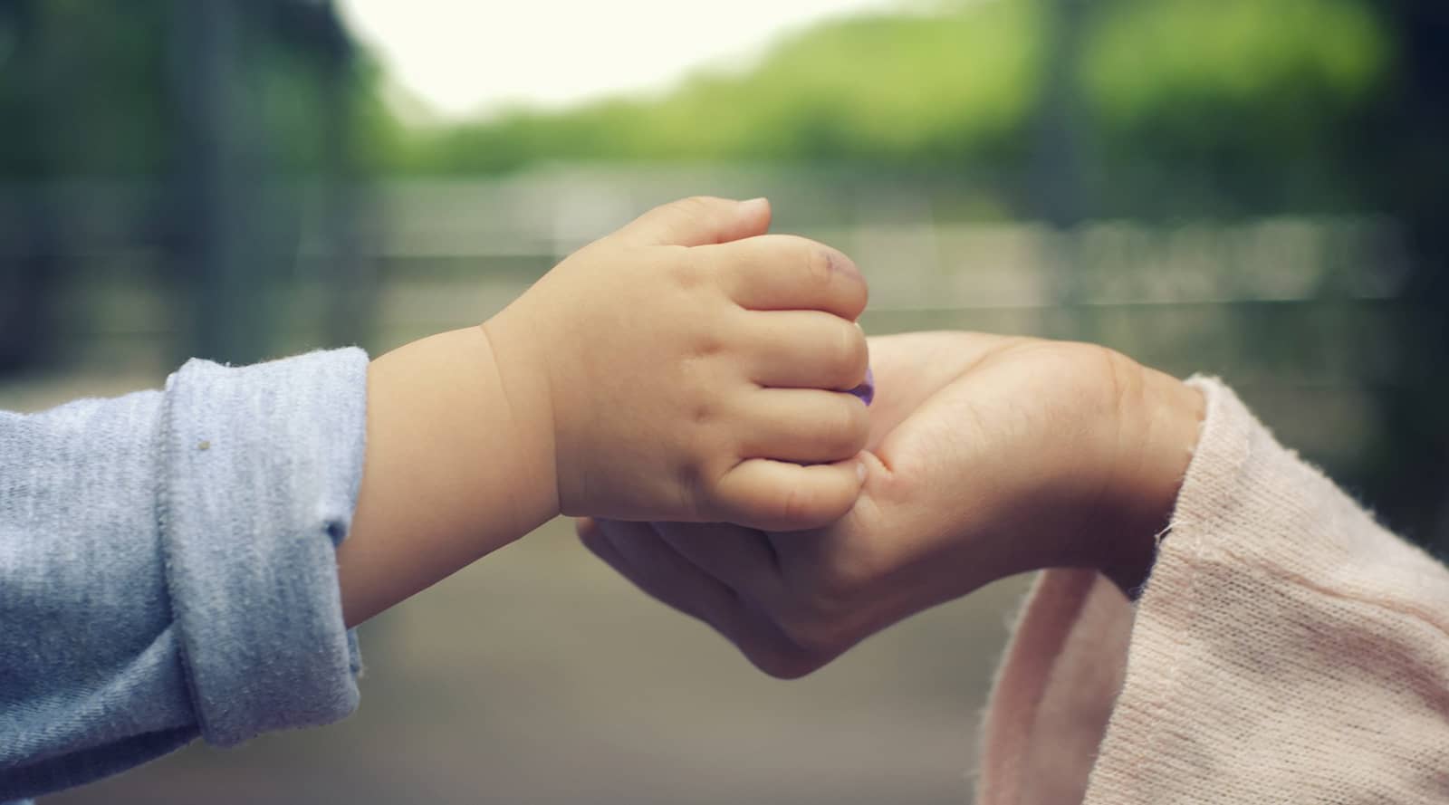 Baby holding a woman’s hand