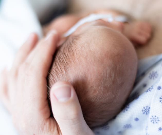 mother-holding-newborn-head